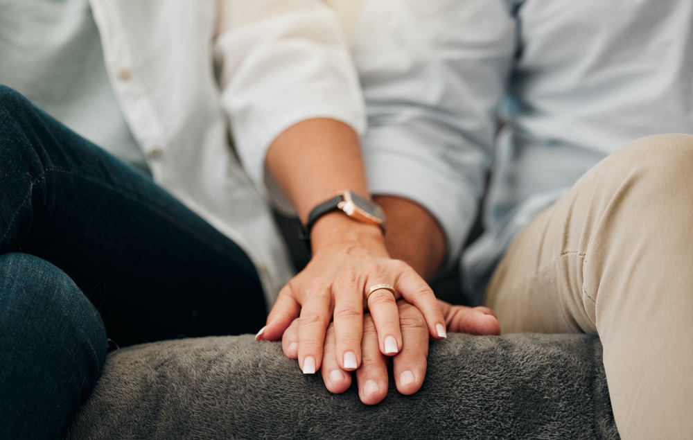 Married couple touching hands