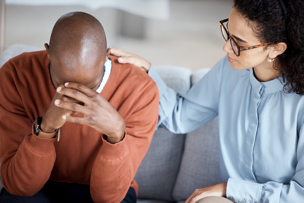 Male patient being comforted by his therapist